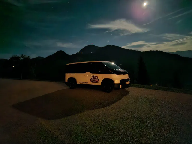 Flos Lieferauto, ein Kia PV5 mit Flo's-Logo, bei Nacht